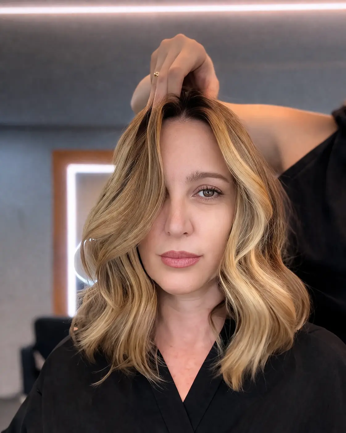 Profissional avaliando o corte e o caimento do cabelo loiro de uma cliente no Lounge Hair Fashion em Moema